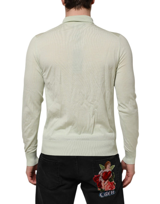Man wearing a beige sweater and black jeans with floral embroidery on back