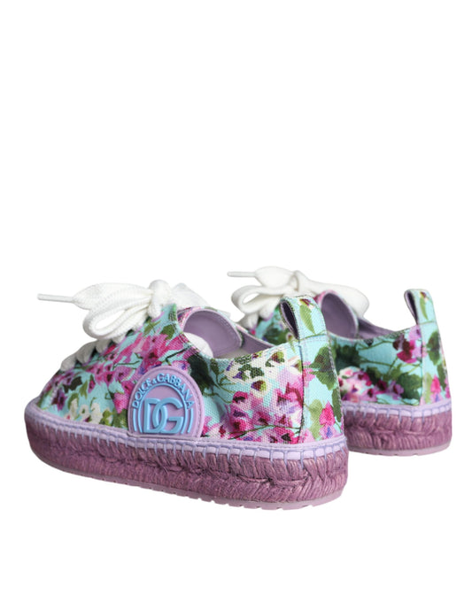 Pair of floral patterned baby shoes with pink soles and a blue logo