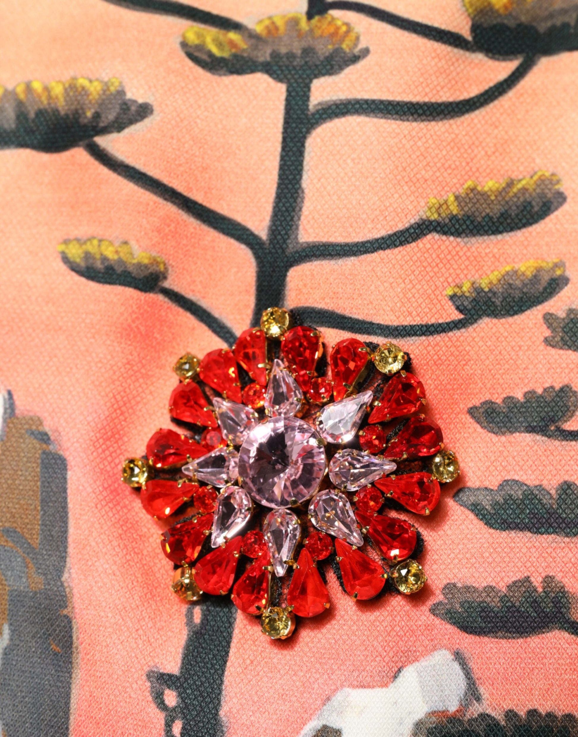 Red, white, and gold crystal embellished brooch on a dress