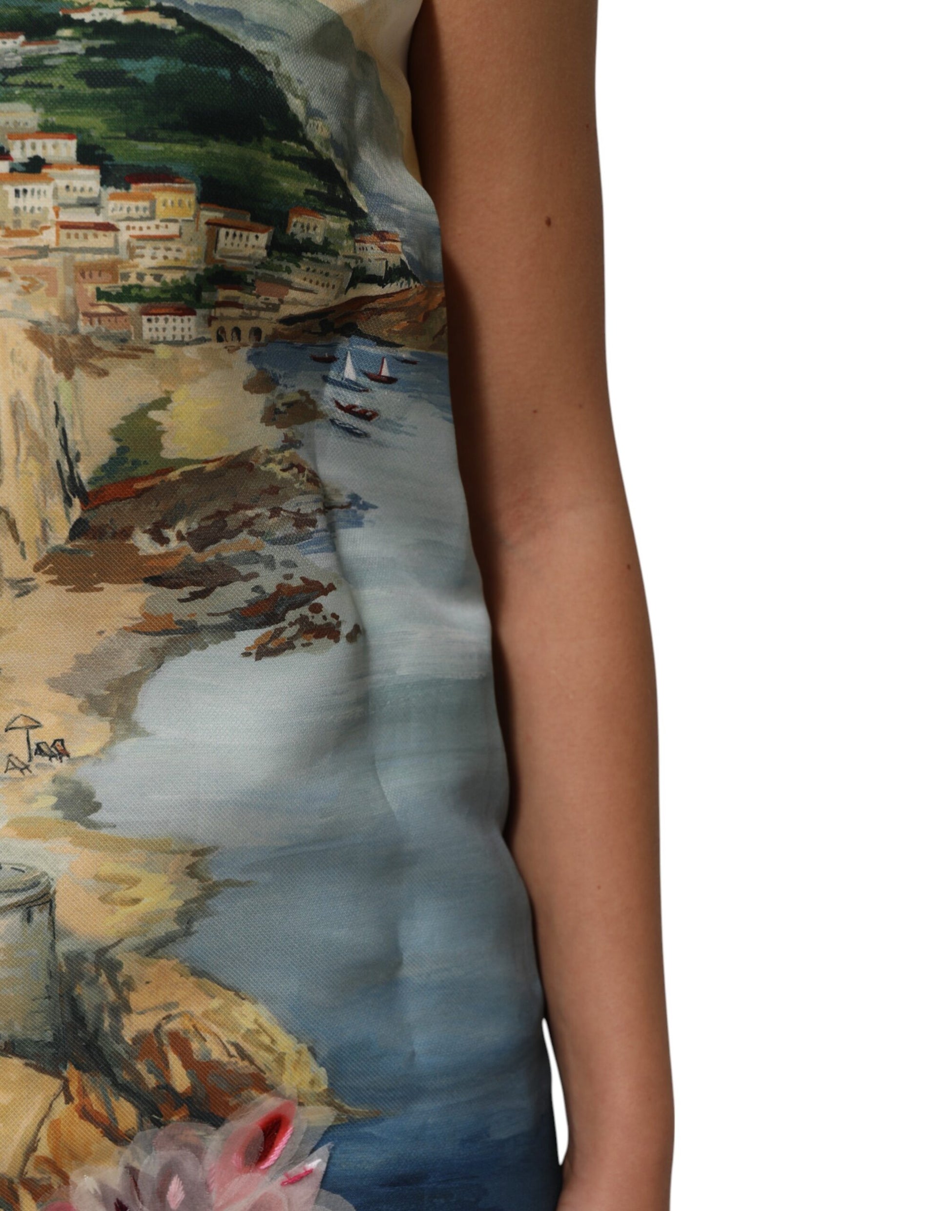 A sleeveless dress with a multicolored crystal embellishment and a painting of a coastal scene