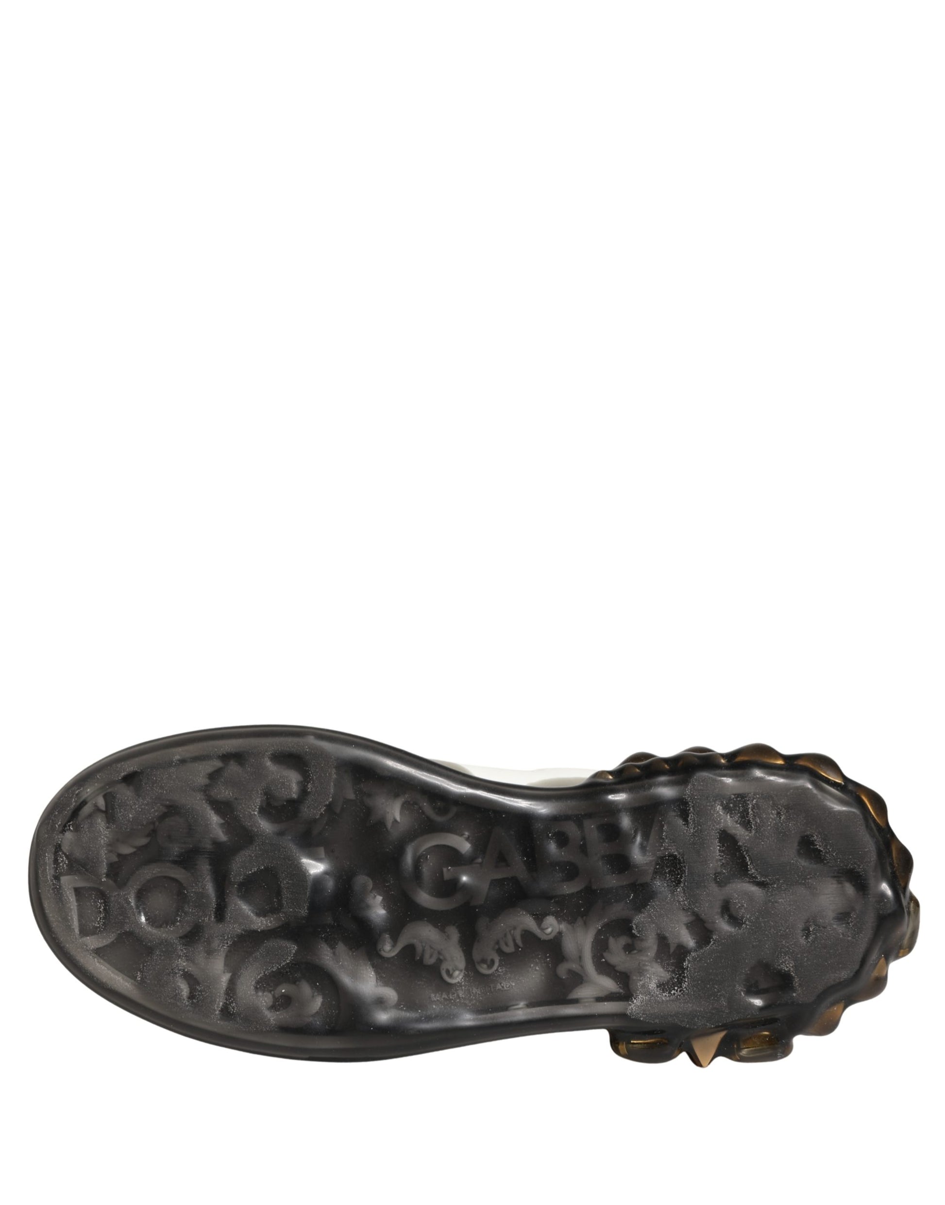 A single black shoe with a crystal studded design on the sole