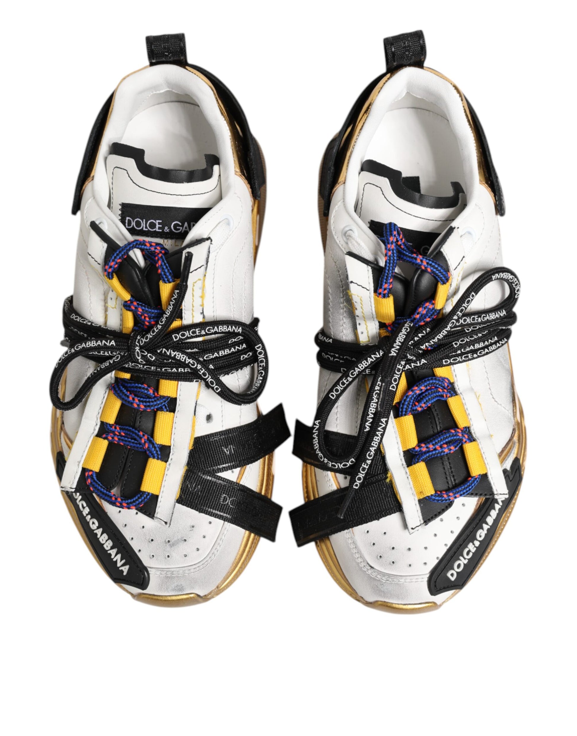 Pair of white sneakers with yellow laces and black straps