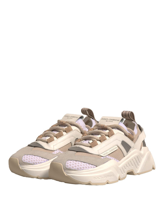 Tan sneakers with white laces and a pink logo on the side