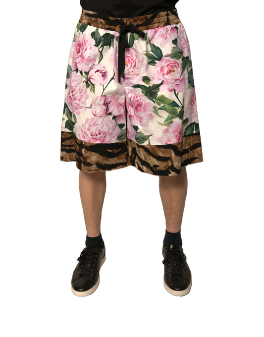 A pair of men's shorts with a floral pattern featuring pink and green flowers on a brown background