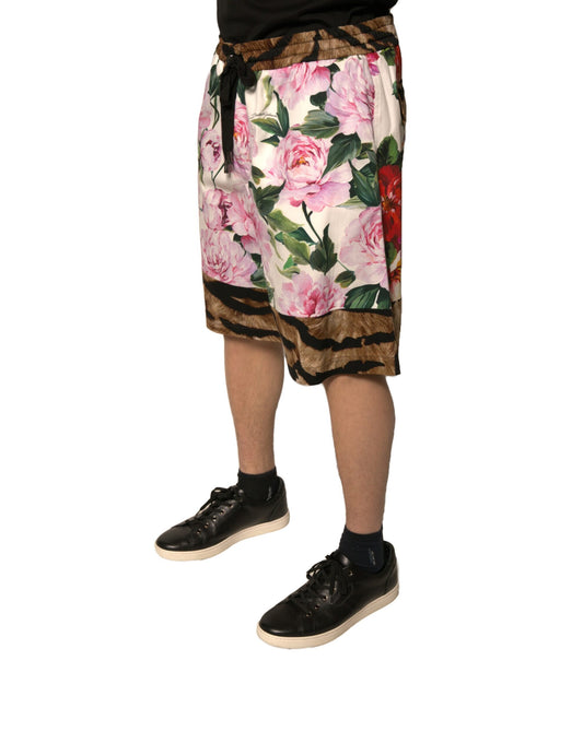 A pair of men's shorts with a floral pattern featuring pink and red flowers on a brown background. They are m