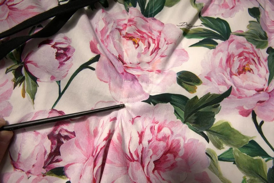 A pair of men's shorts with a floral pattern featuring pink and green flowers