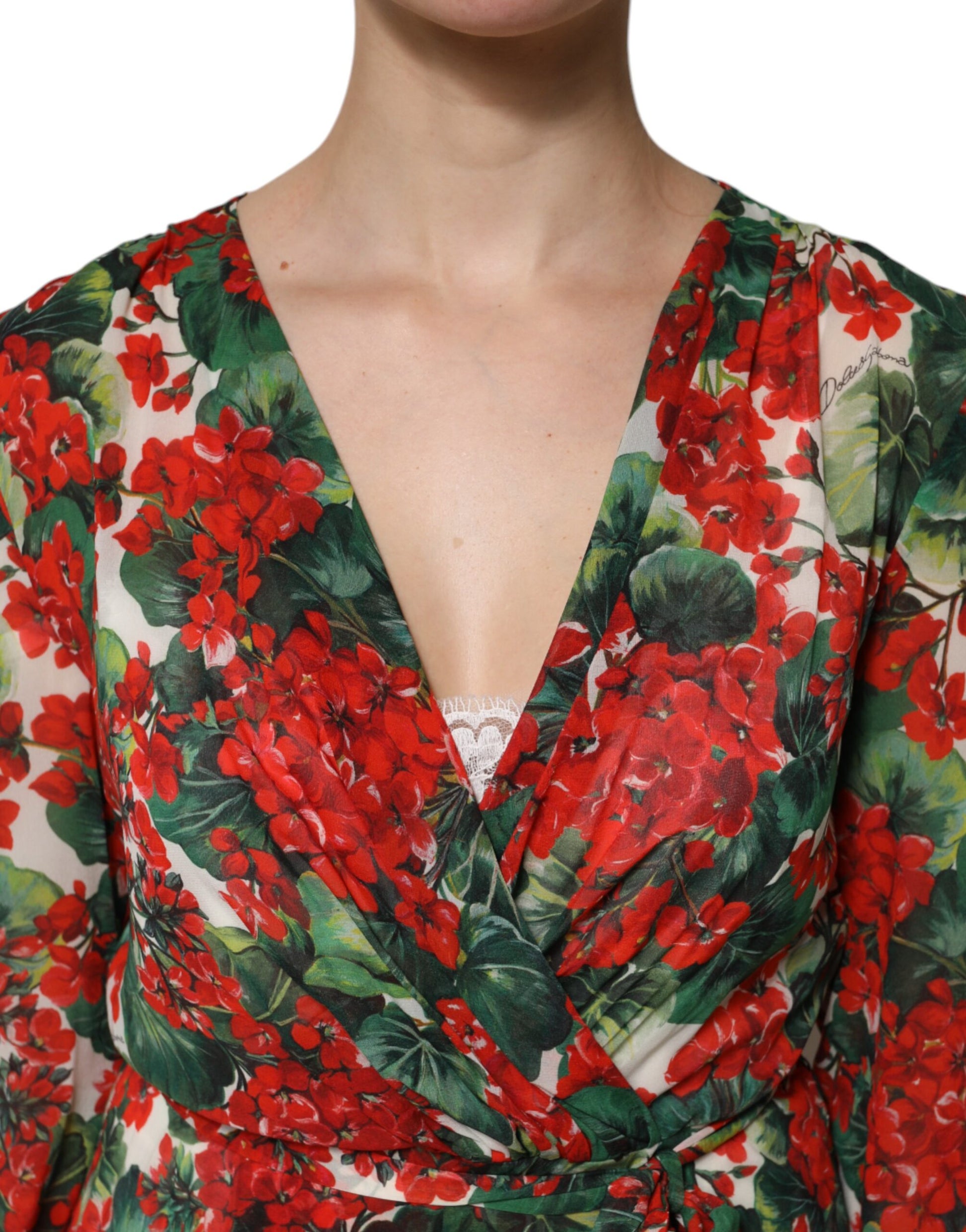 A woman wearing a long sleeve, v-neck dress with floral pattern