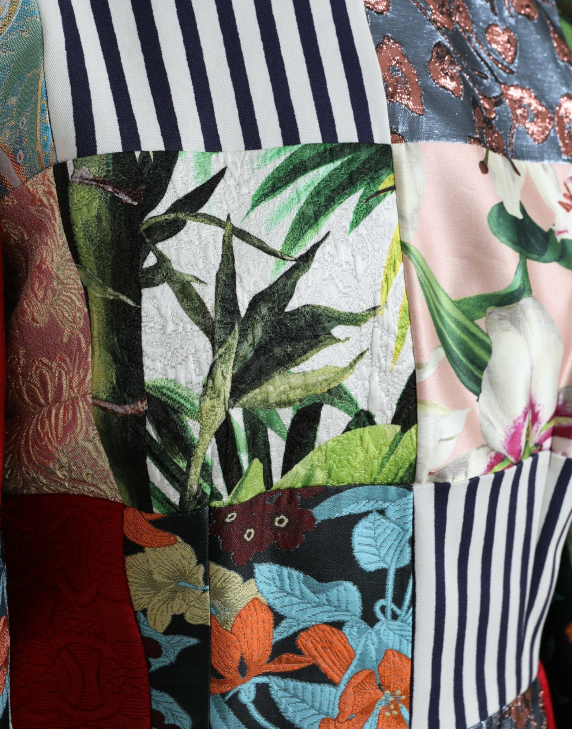A colorful floral patchwork dress with a shift silhouette, featuring a mix of patterns and textures