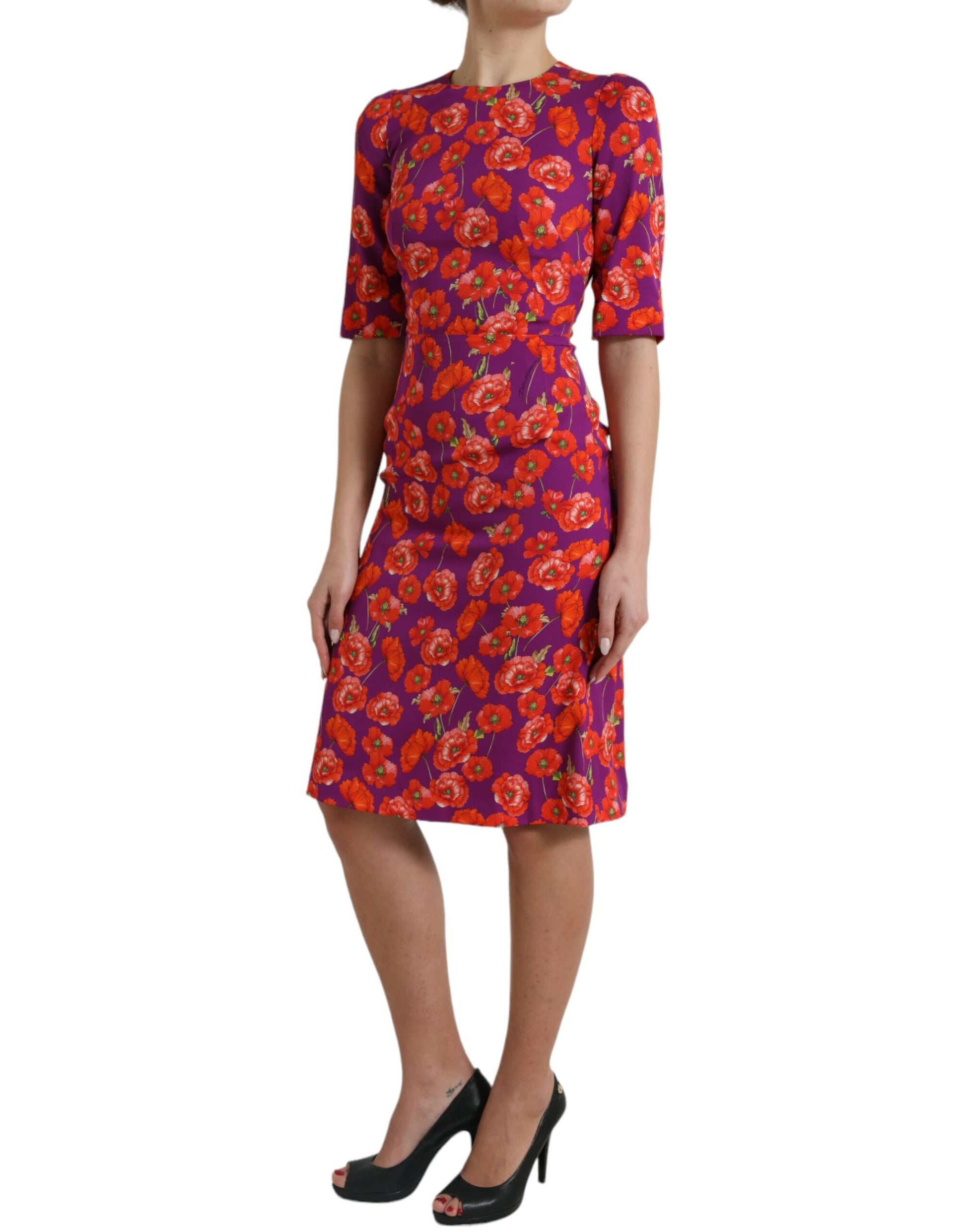 A woman wearing a red, purple, and black floral print dress with short sleeves