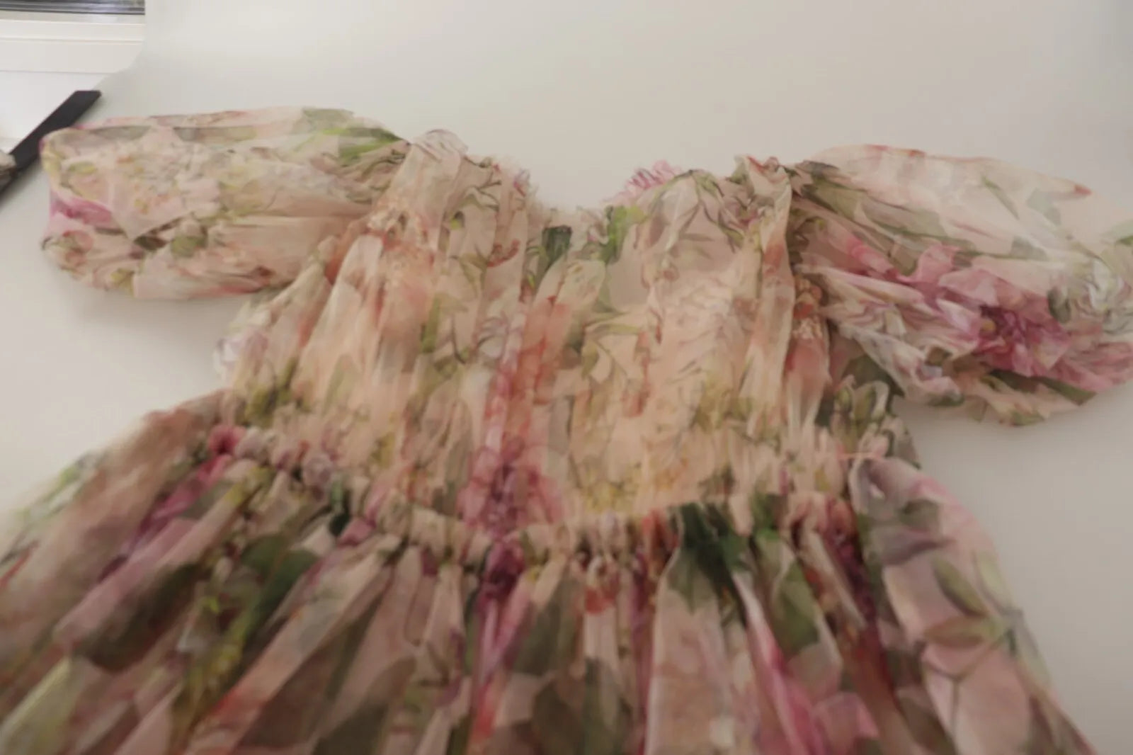 A long, multicolored floral print dress with a flowing design and sleeves