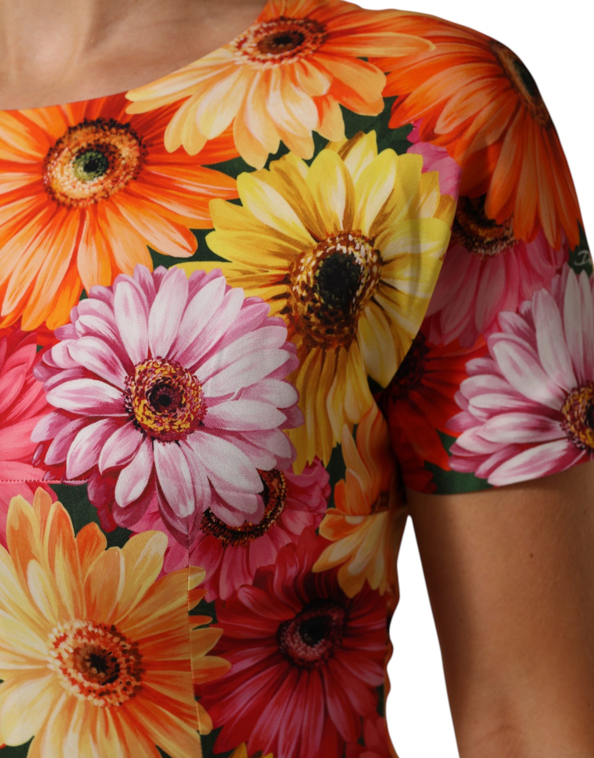 A woman's sleeveless dress with a floral print of pink, yellow and orange flowers