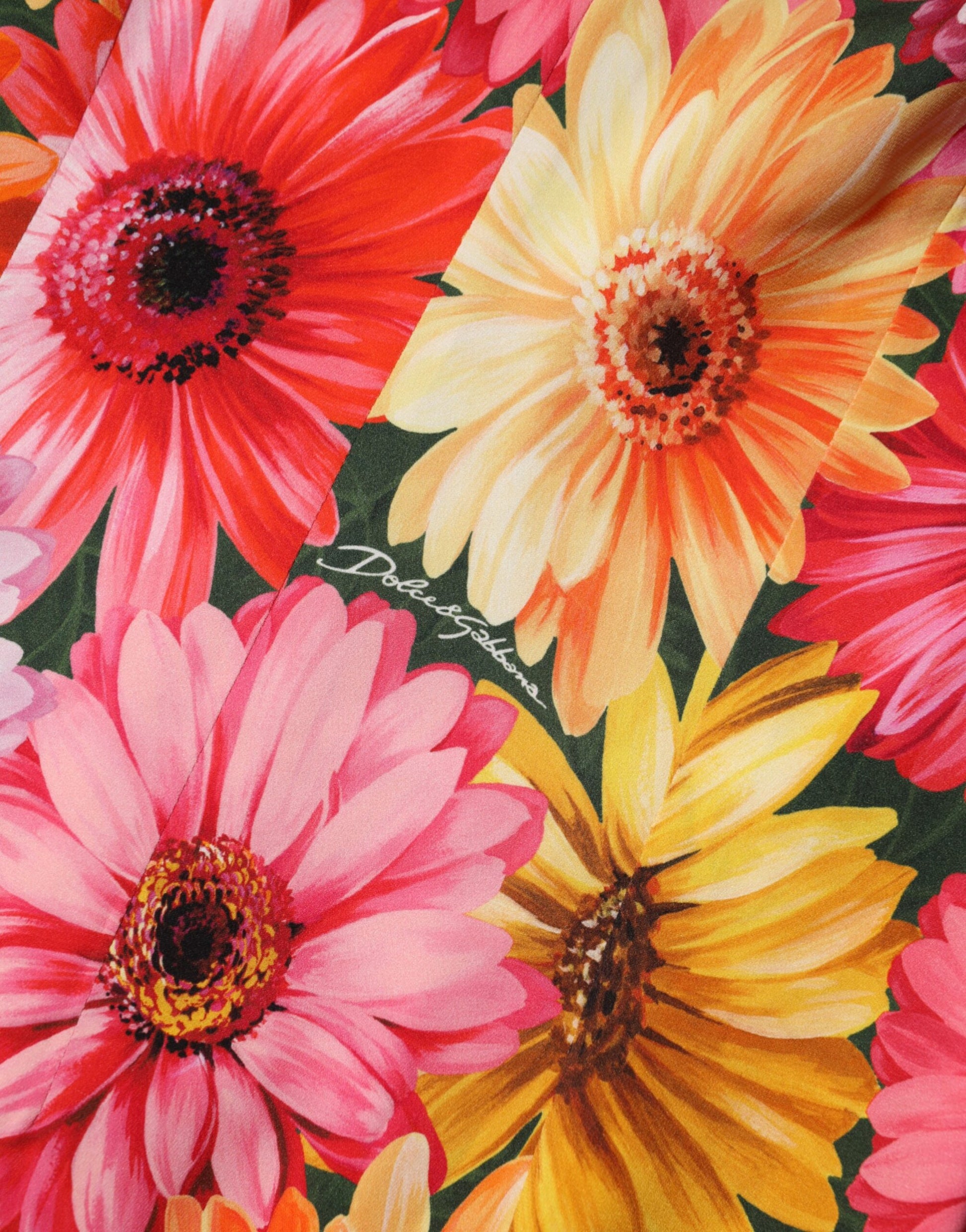 A vibrant floral print midi dress with a silky texture, featuring pink and yellow flowers on a green background