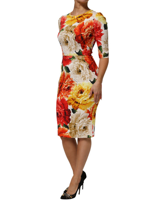 A woman wearing a multicolored floral print dress with short sleeves and a sheath silhouette