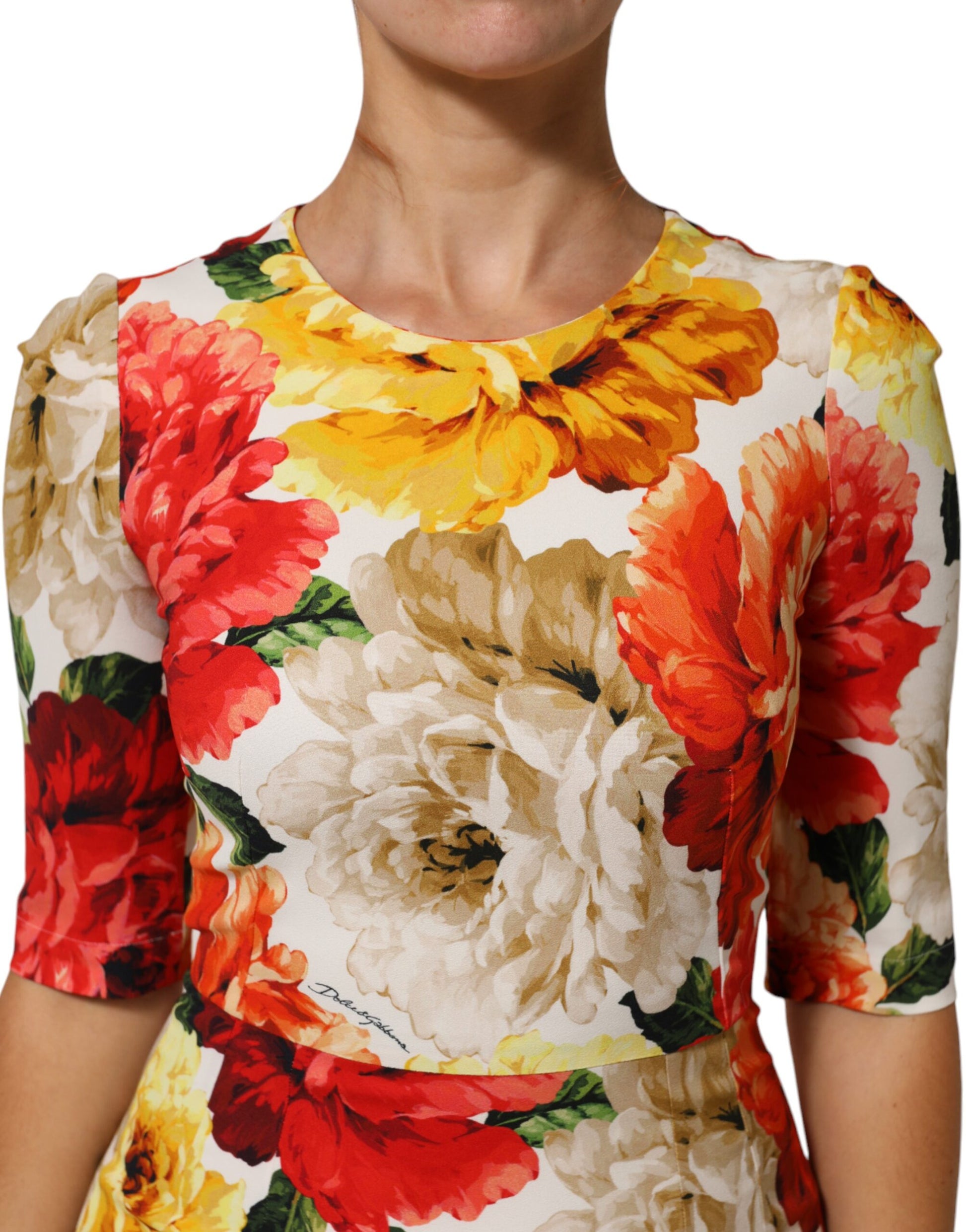 A woman wearing a multicolored floral print dress with long sleeves