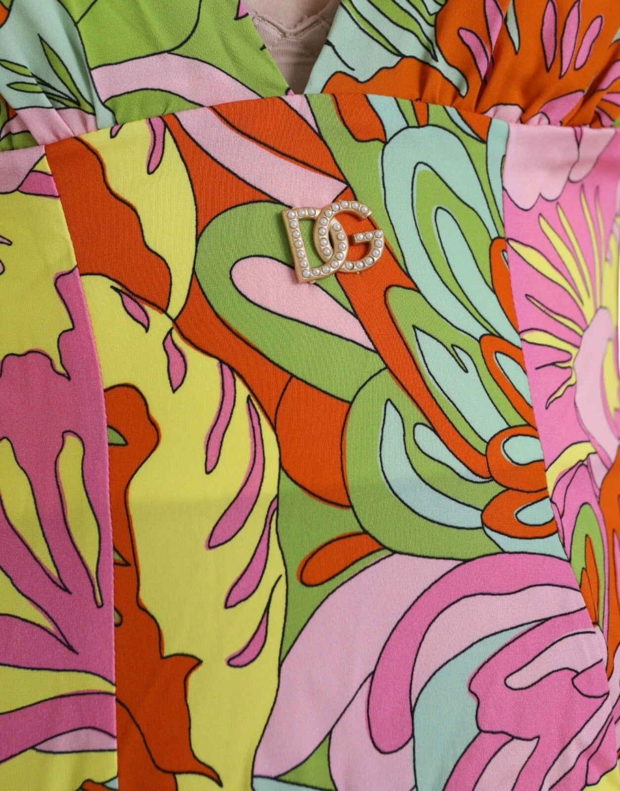 A colorful flared mini dress with a floral pattern and a shiny silver buckle