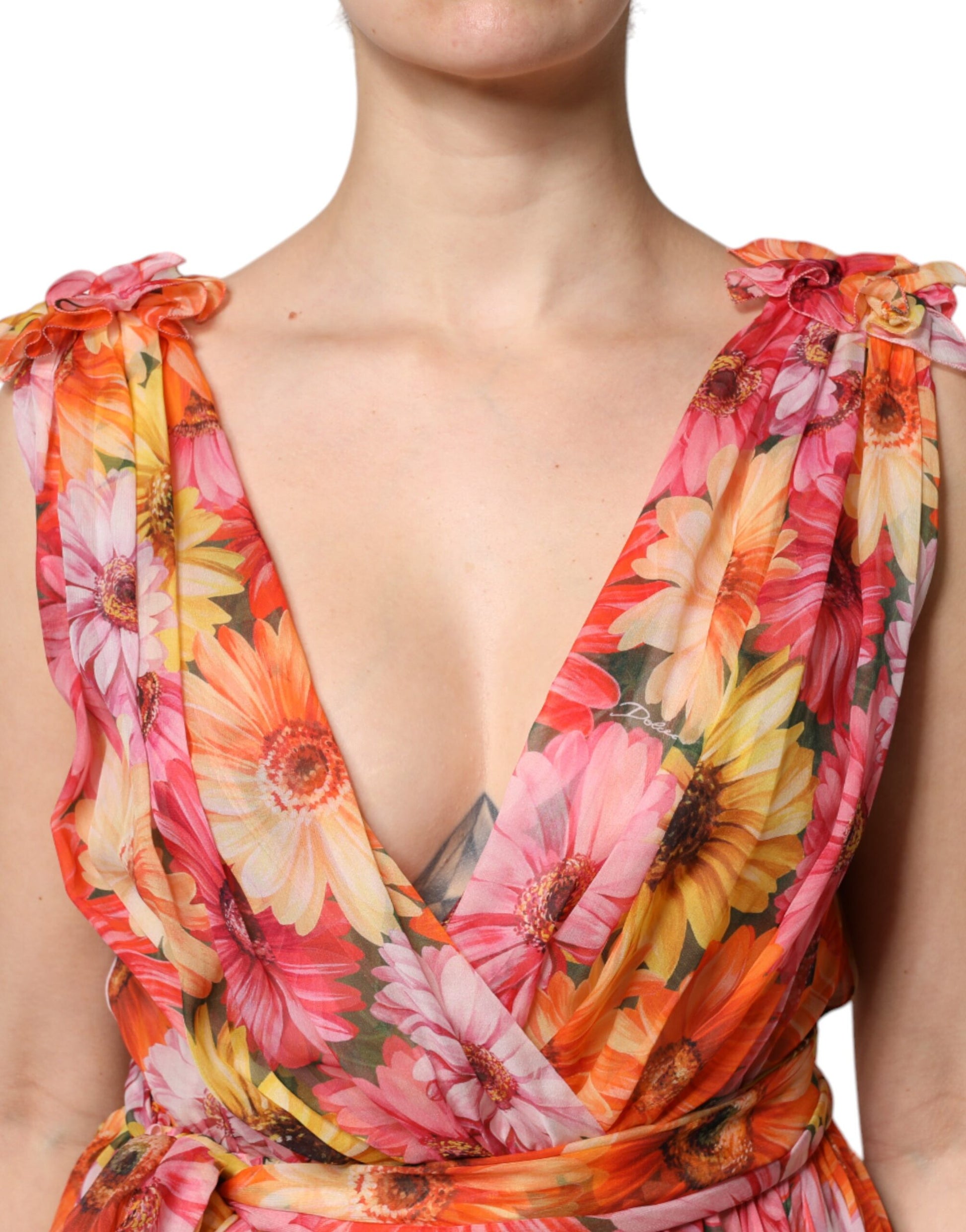 A woman wearing a multicolored floral silk chiffon dress with a V-neck