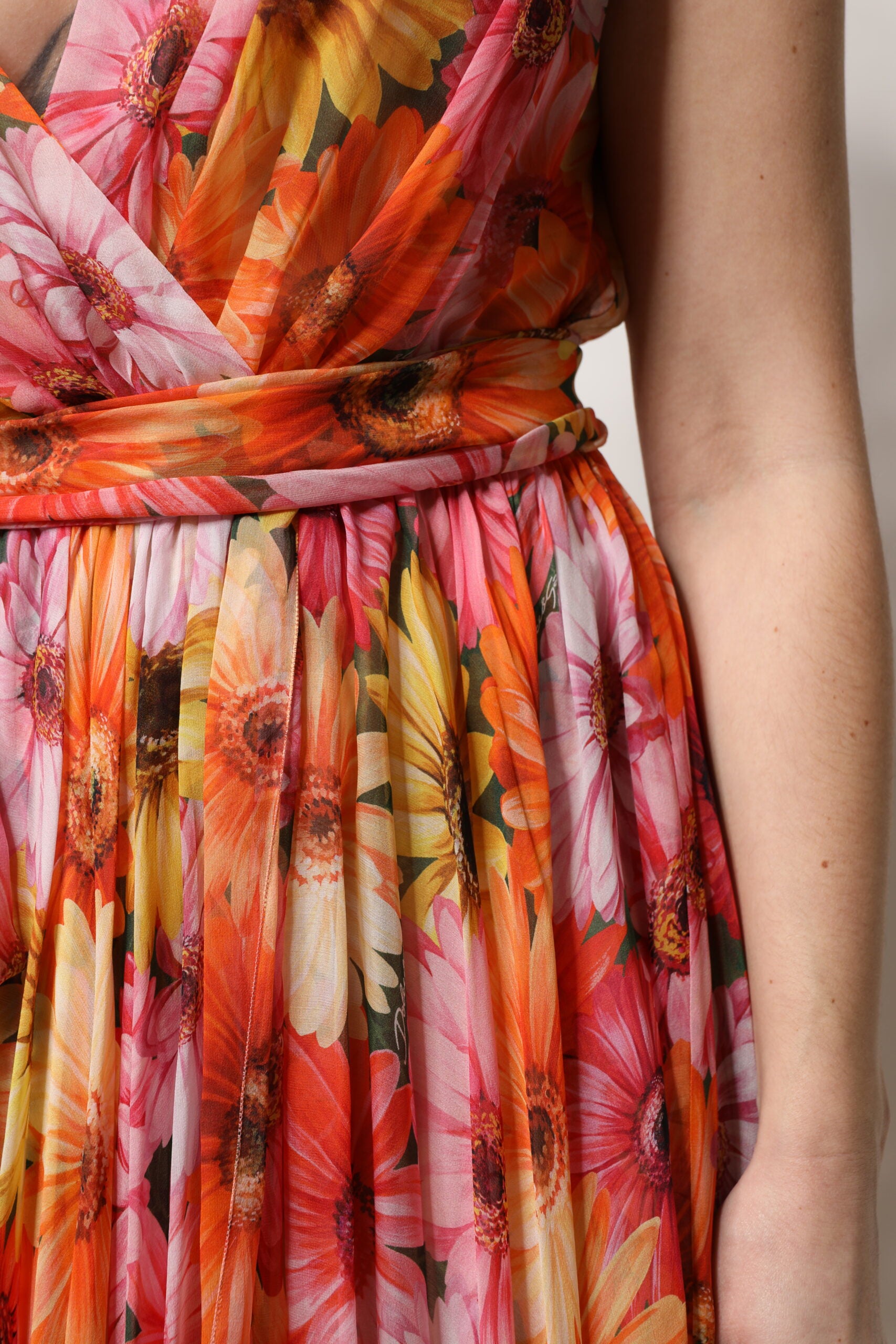A woman wearing a multicolored floral silk chiffon dress with a V-neck