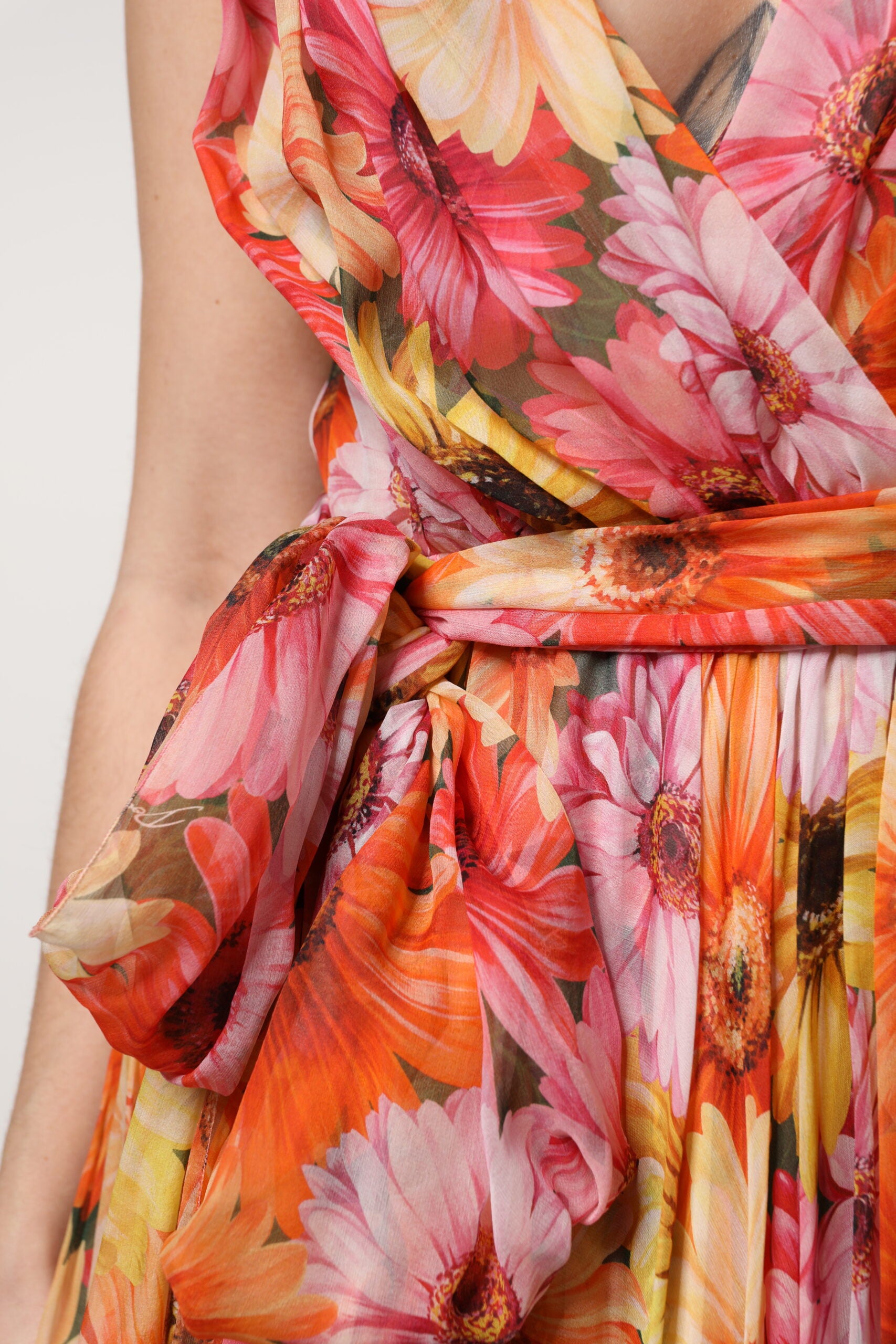 A woman wearing a multicolored floral silk chiffon dress with a V-neck