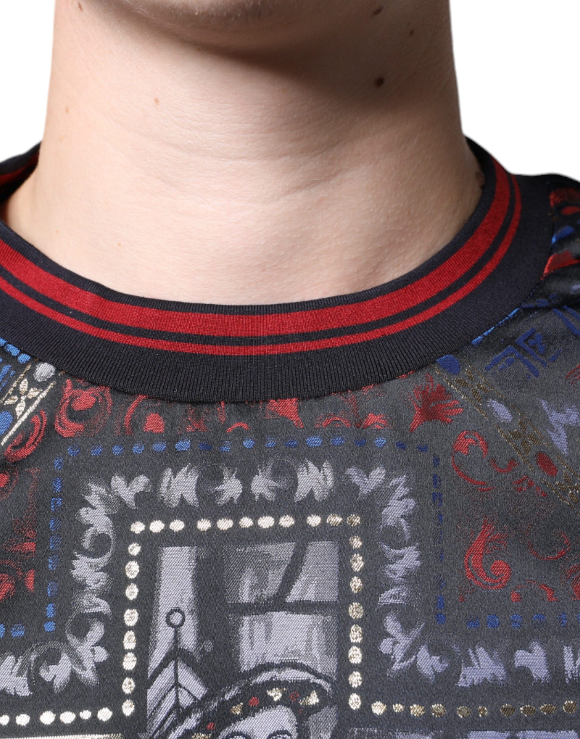 A person wearing a colorful garment with a patterned design on the front. The garment features a prominent gr