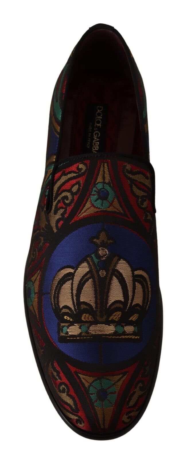 Decorative loafer with embroidered crown and intricate designs on a blue background