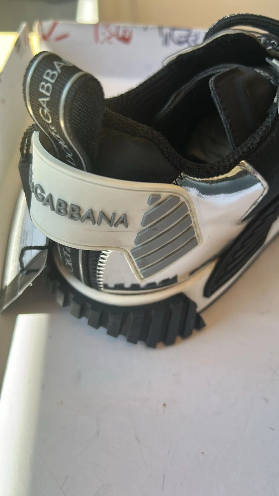 Black and white baseball glove with brand name on wristband