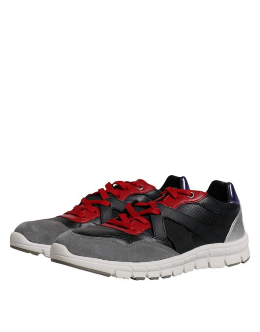 Pair of athletic shoes with red laces and a black design on top