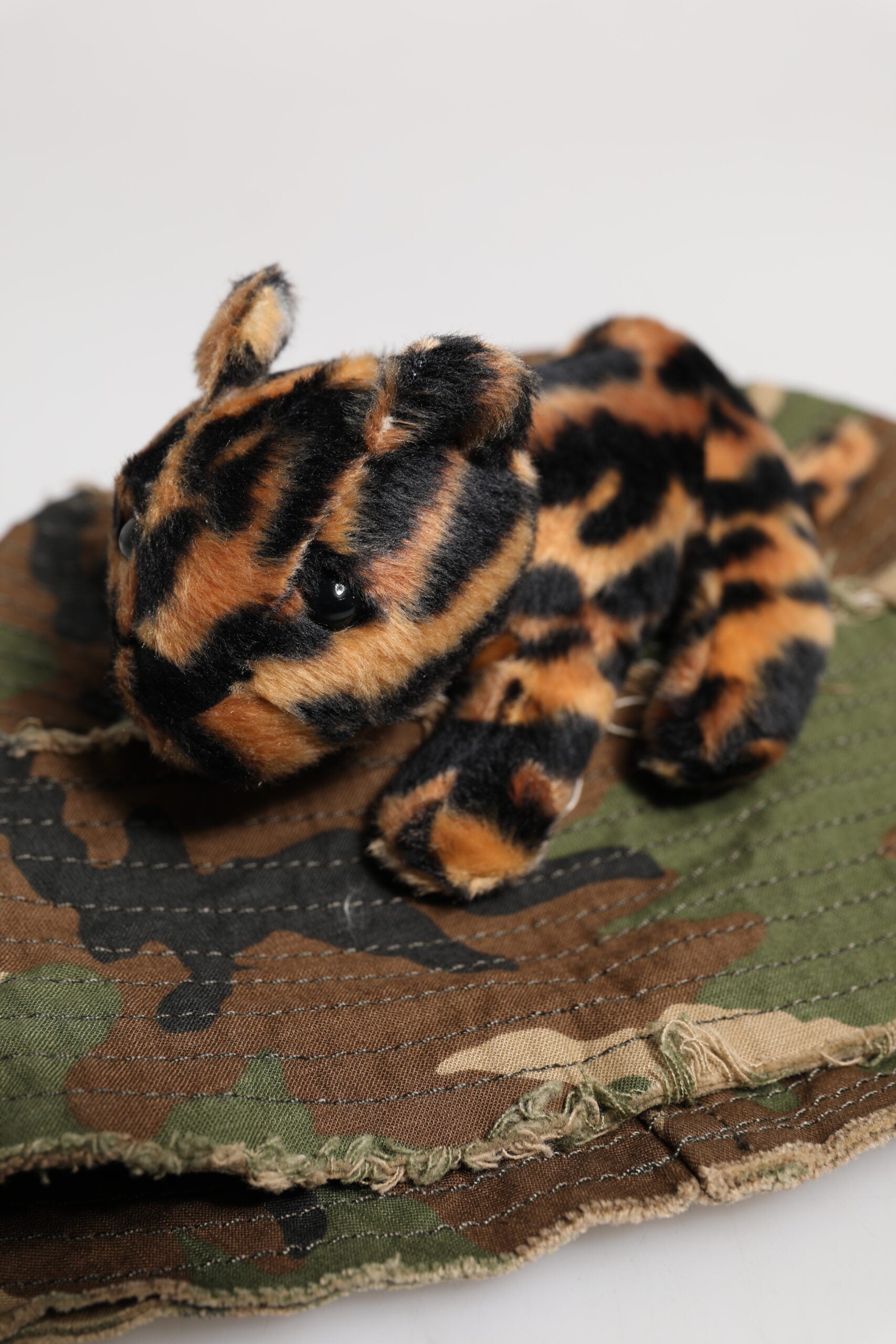 Stuffed animal on camouflage fabric