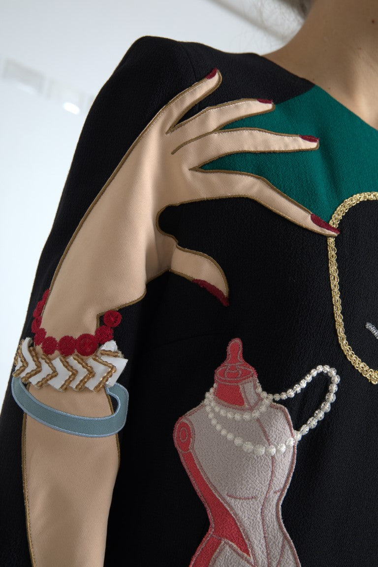 A person wearing a long sleeve dress with a multicolored design. The dress features embellishments and is par