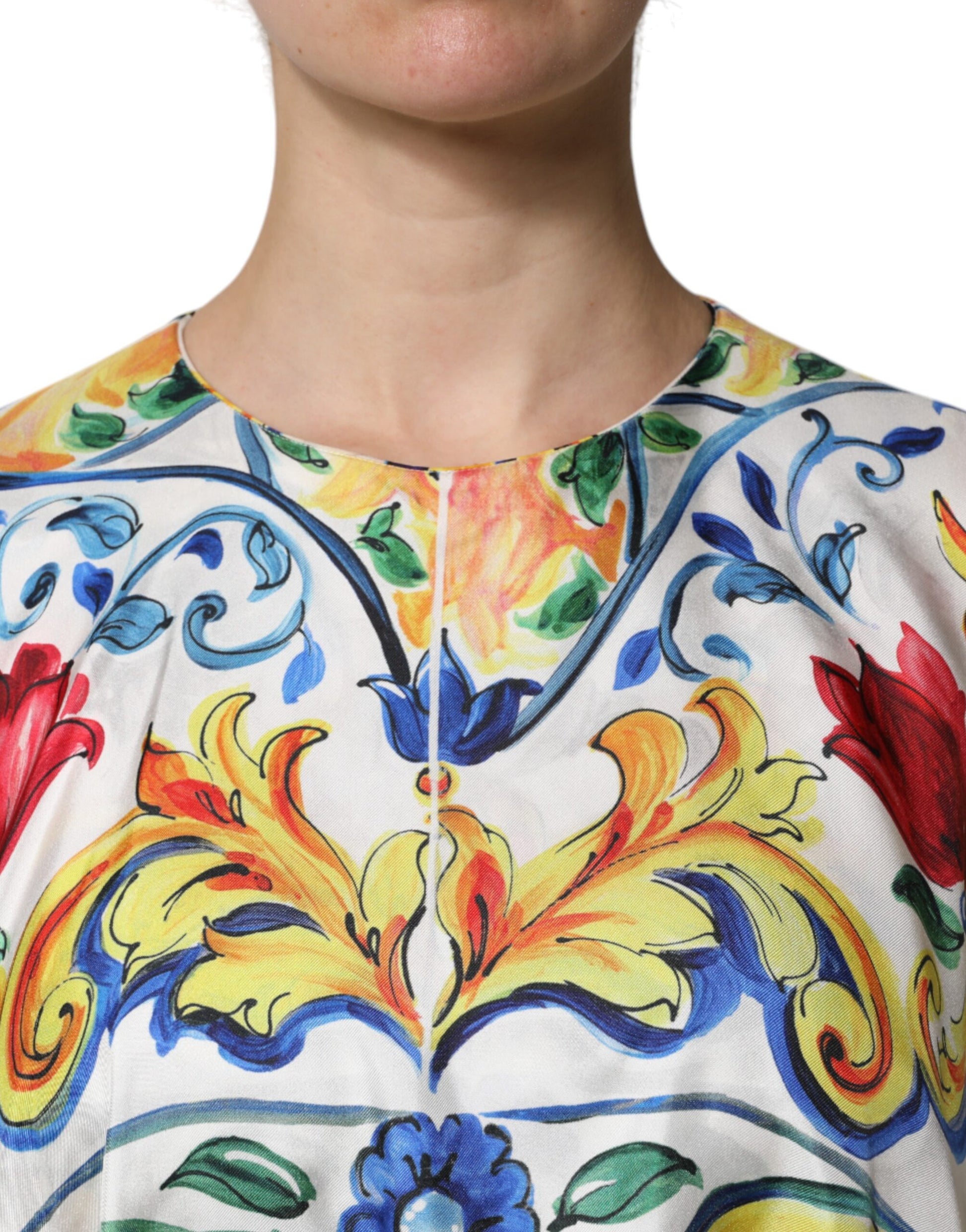 A woman wearing a colorful, embroidered maxi dress with short sleeves