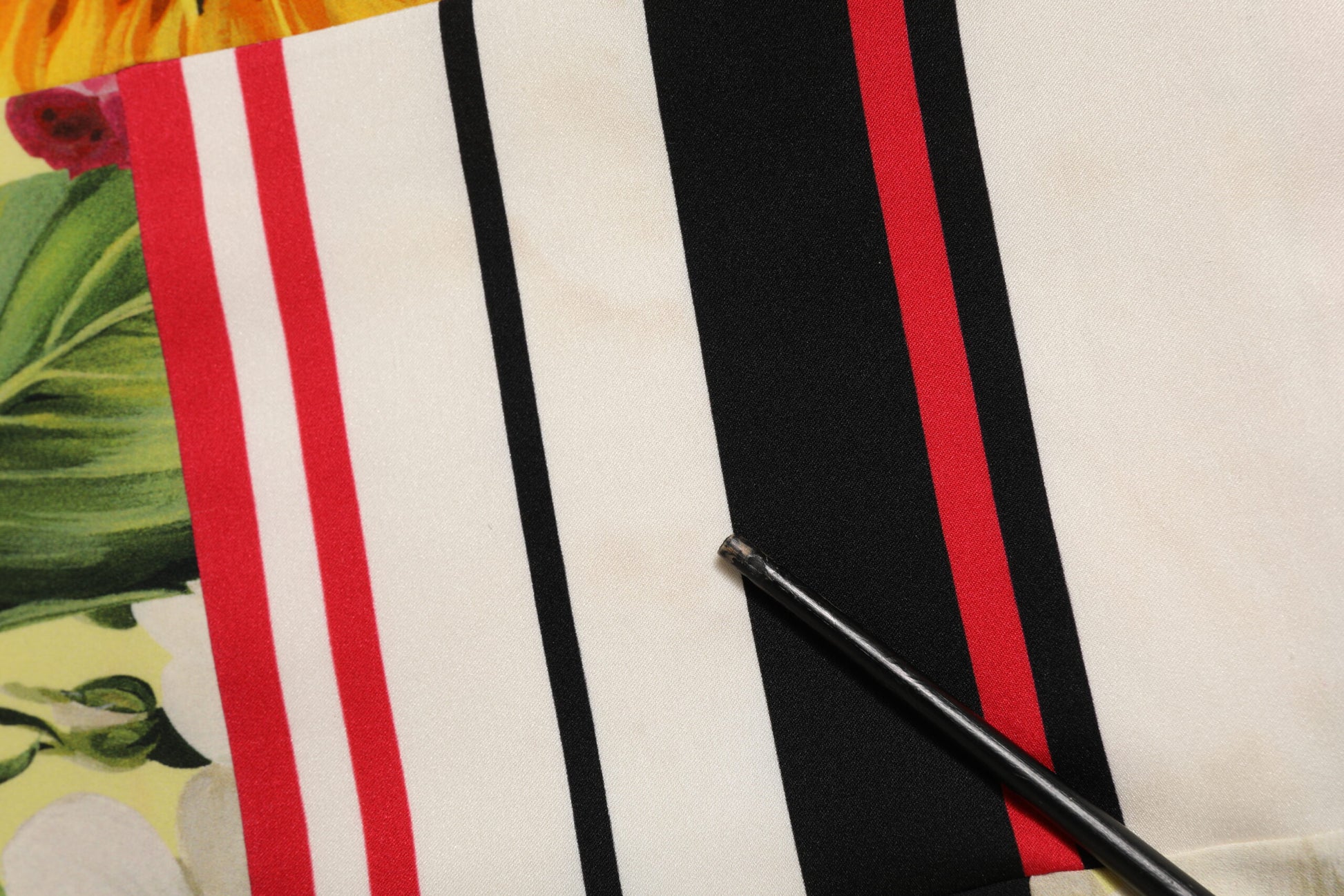 A multicolored pachwork charmeuse floral shift dress with red, white, and black stripes