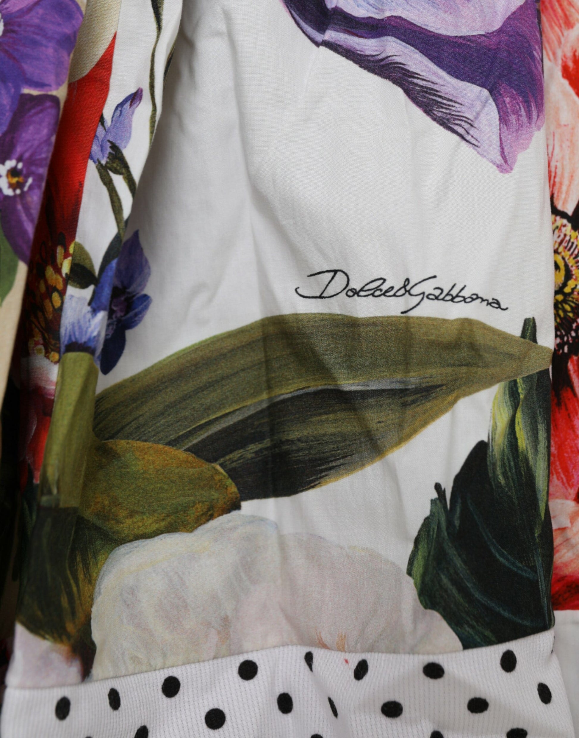 A colorful aline mini dress with floral and leaf patterns, made of cotton