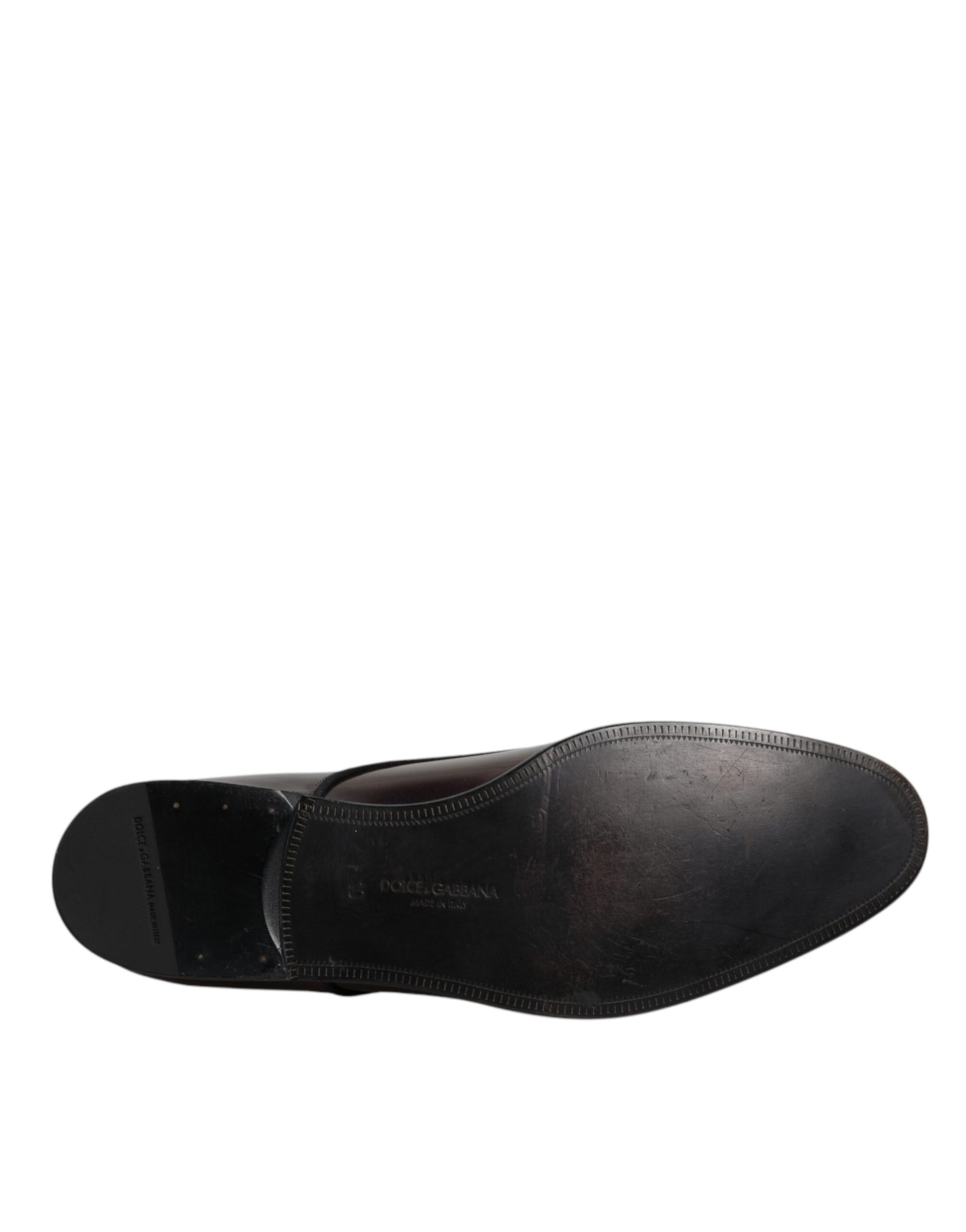 A single black dress shoe with a peacock print design on the side