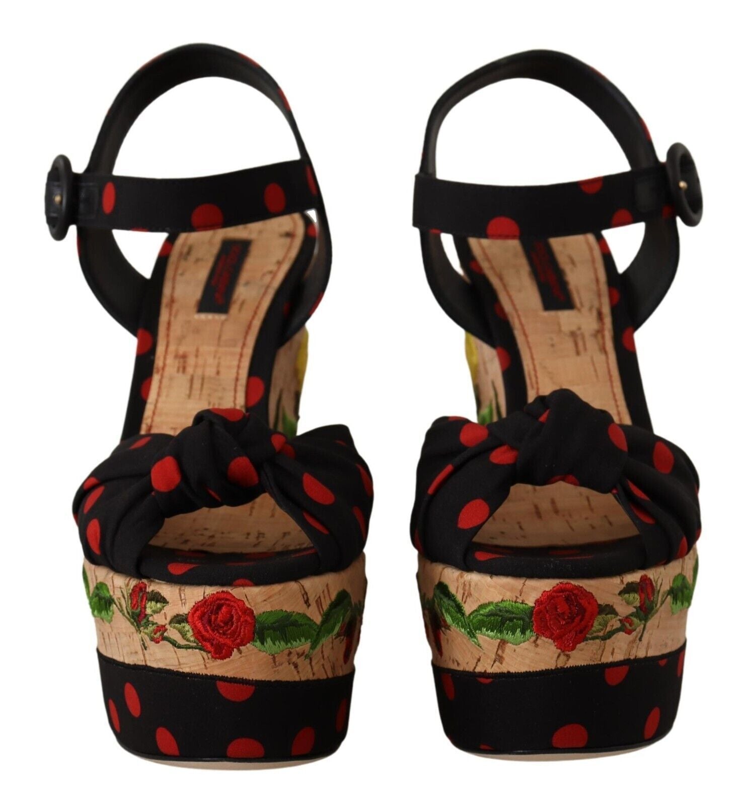Pair of high heel shoes with red polka dots and floral designs on a wooden base
