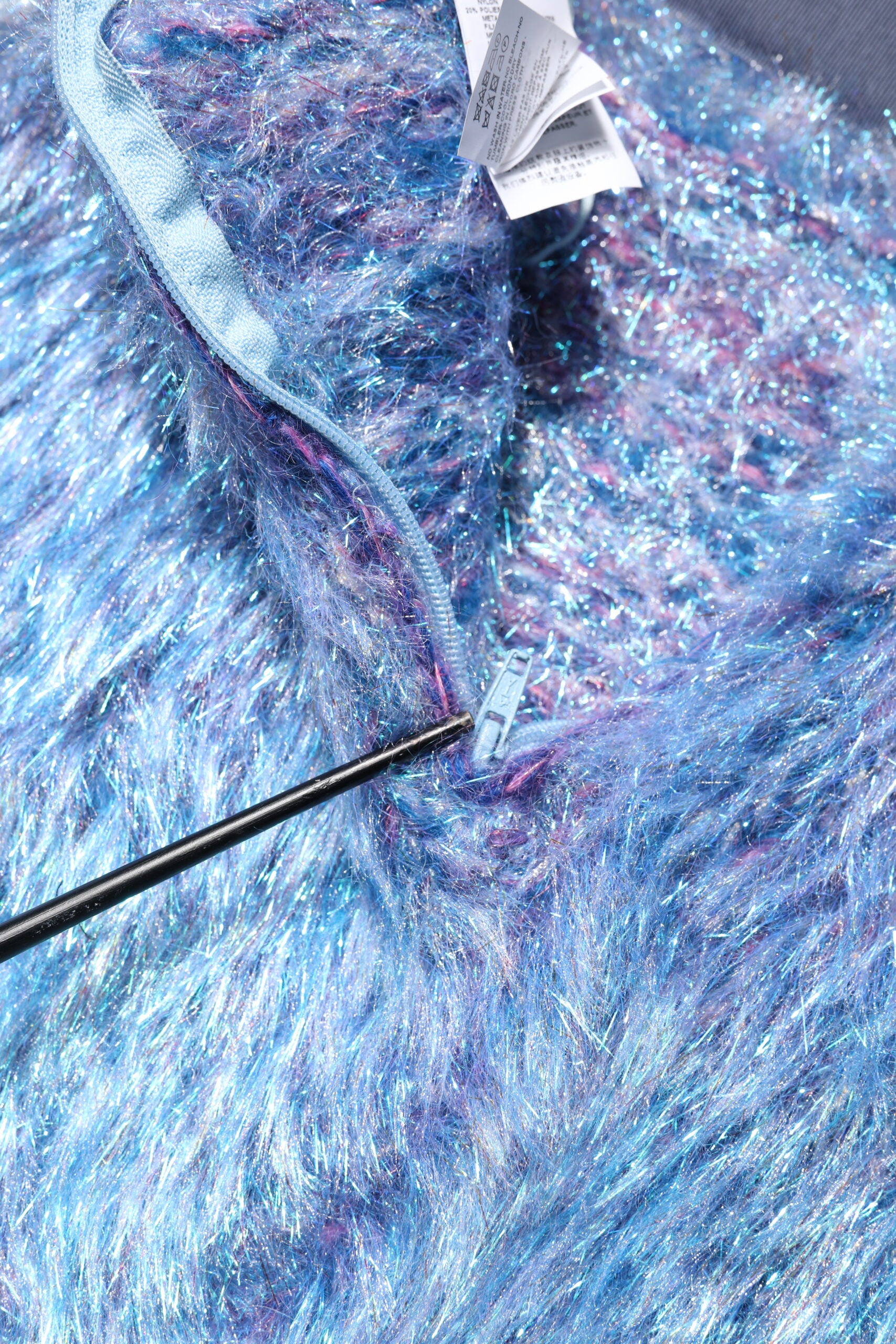 Blue fuzzy fabric with a tag attached to it