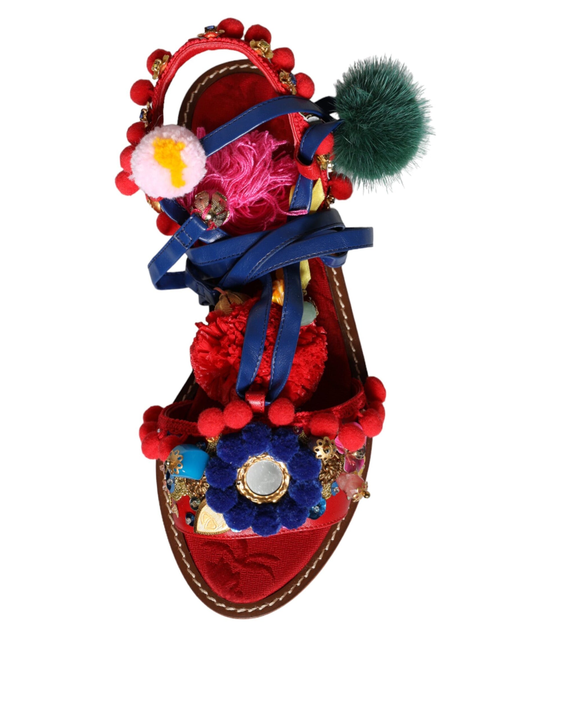 Decorative sandal with red base, blue straps, pink and green beads, and a large pom pom on top