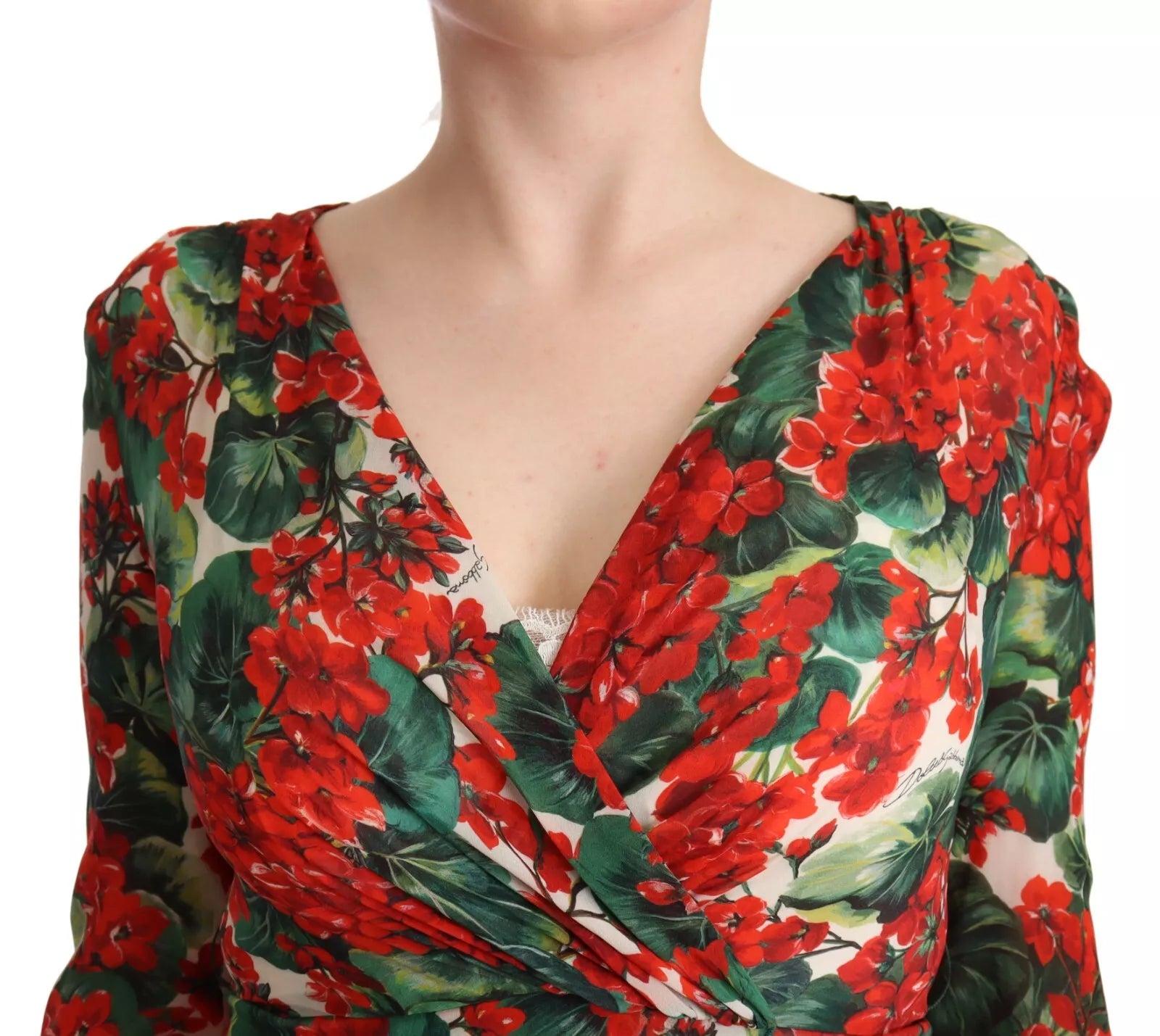 A woman wearing a red, green, and white floral print dress with a V-neckline
