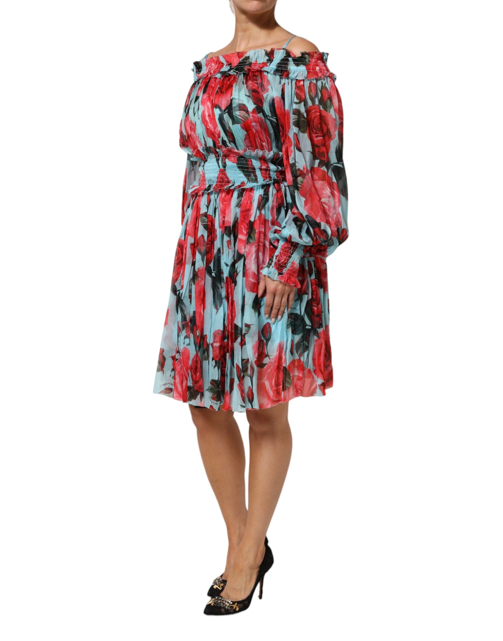 A woman wearing a multicolored floral chiffon dress with long sleeves and ruffled shoulders