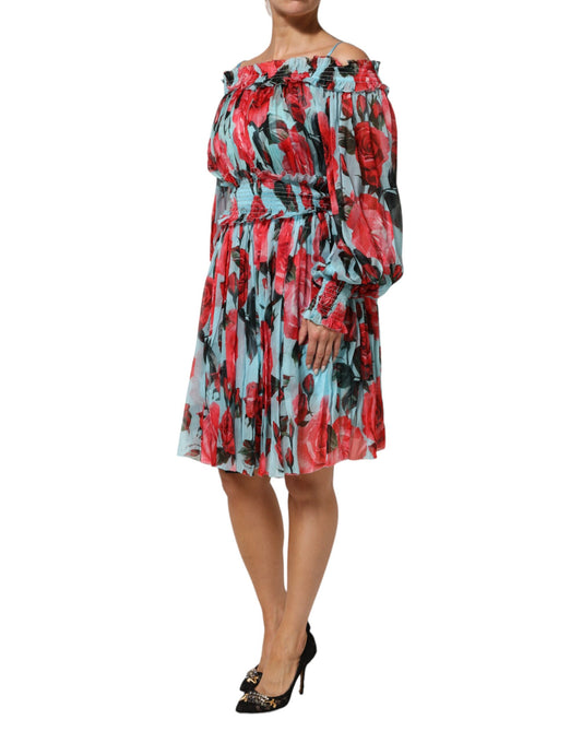 A woman wearing a multicolored floral chiffon dress with long sleeves and ruffled shoulders