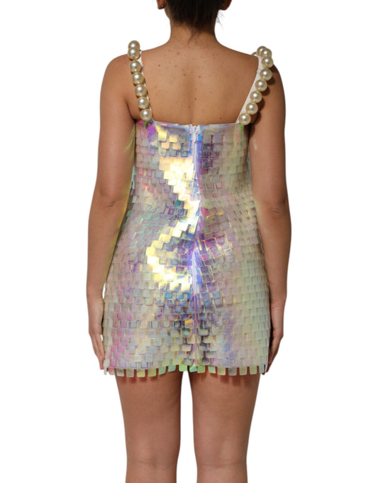 A woman wearing a holographic sequin mini dress with multicolored patterns