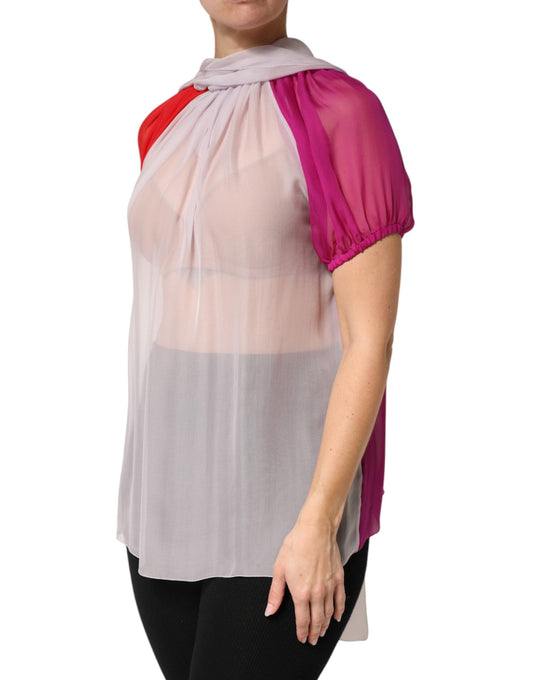 Woman wearing a sheer white top with pink ruffles on sleeves