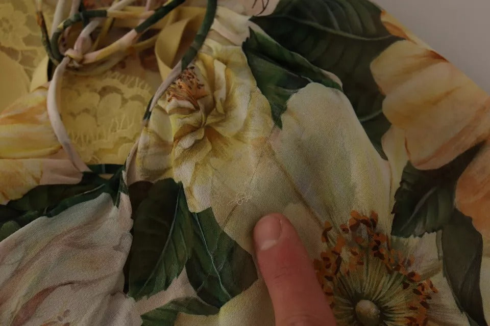 A person's hand touching a multicolored silk floral print long maxi dress