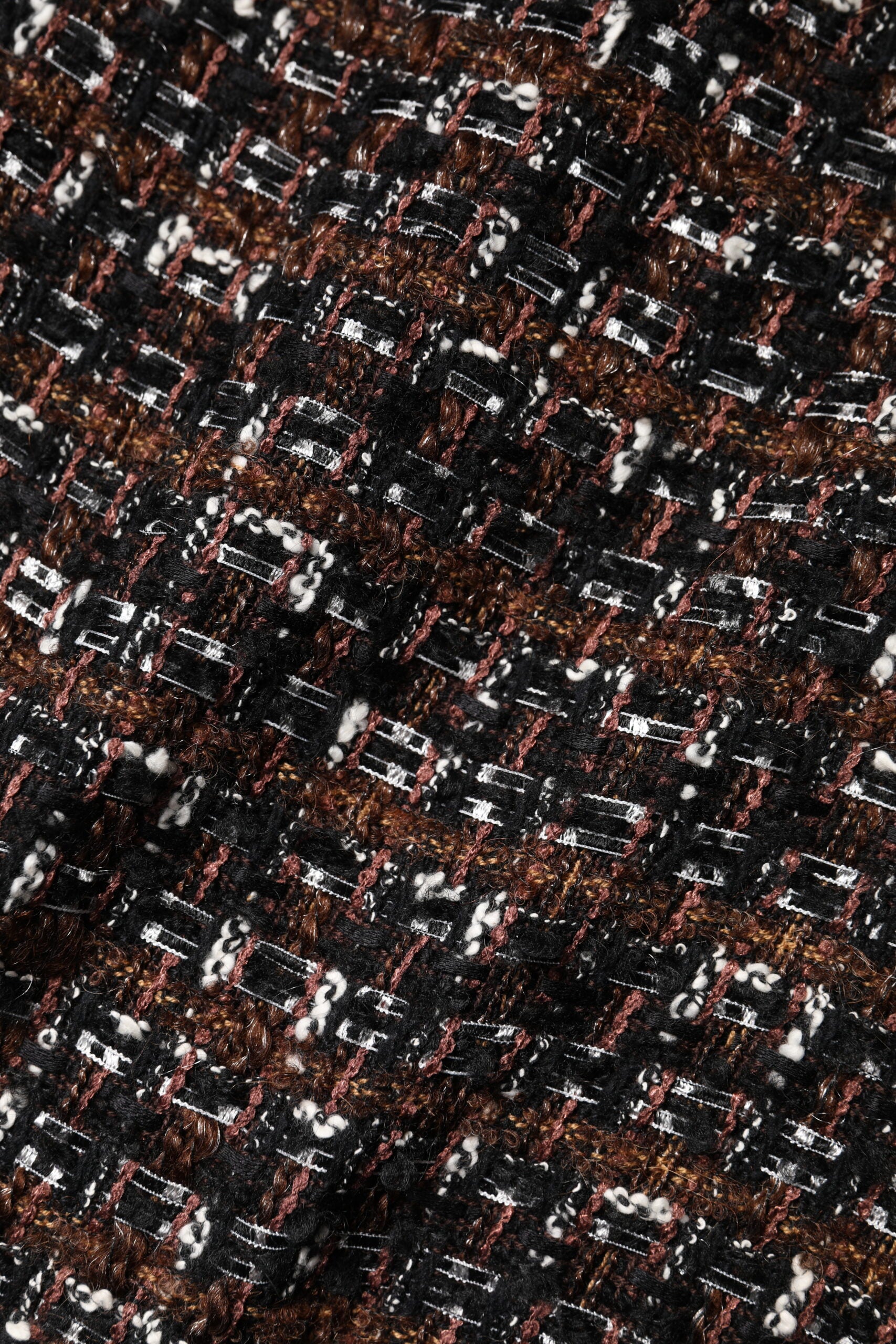 A close-up of a multicolored sleeveless mini tweed dress