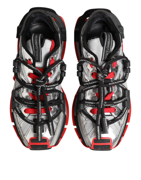 Pair of men's sneakers with red and white laces, black straps, and a silver buckle