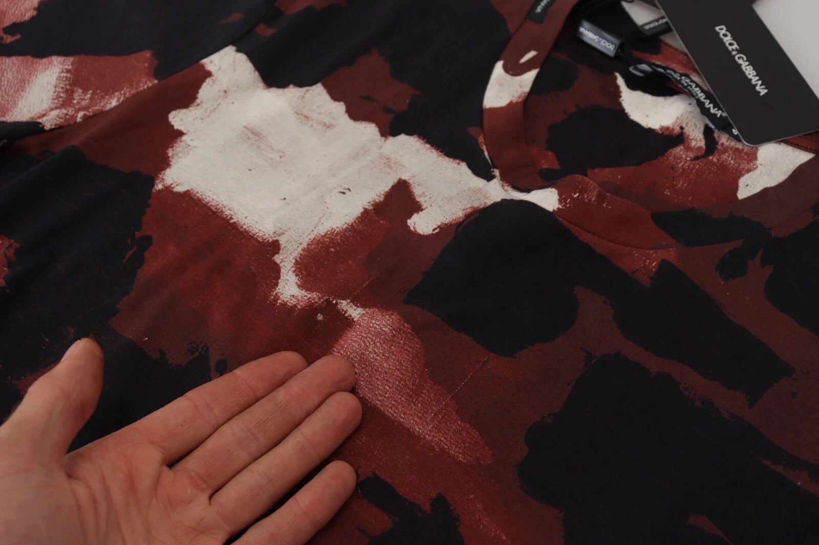 Hand touching camouflage patterned fabric