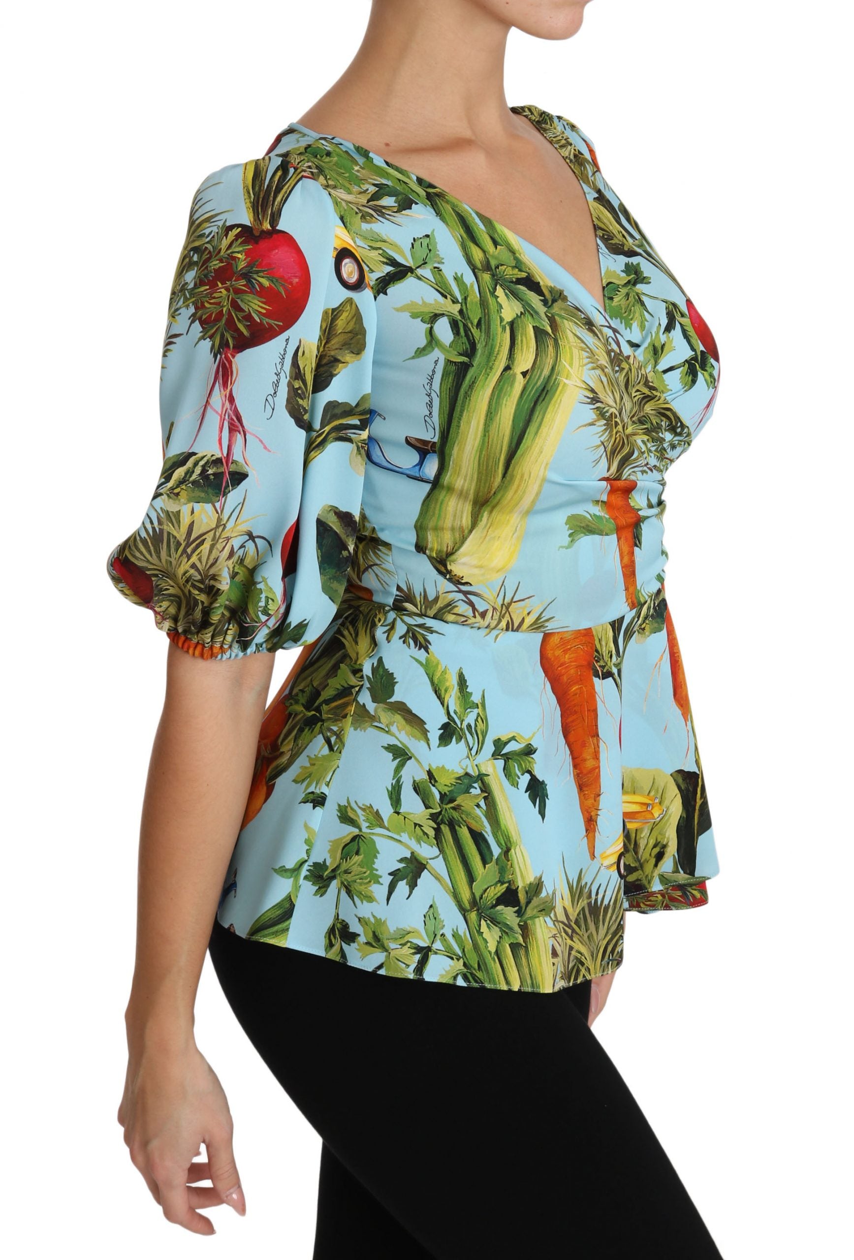 The shirt is colorful with a floral pattern featuring fruits and vegetables