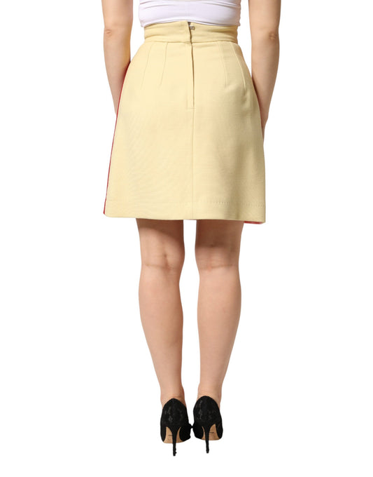 Tan skirt with red trim worn by a woman standing against white background