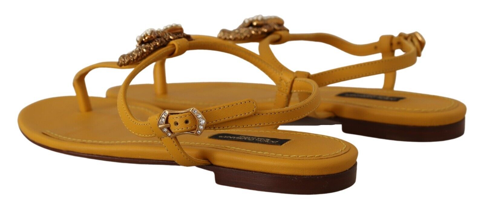 Yellow strappy sandals with embellishments on top of footbeds