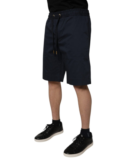 Man wearing black shoes and dark blue shorts