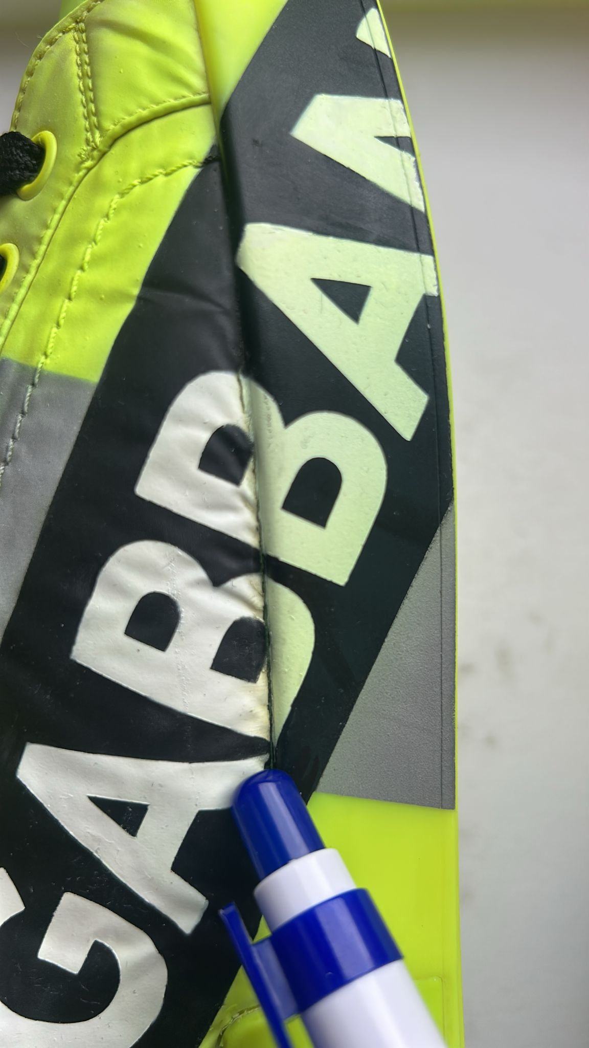 Yellow soccer cleat with black writing