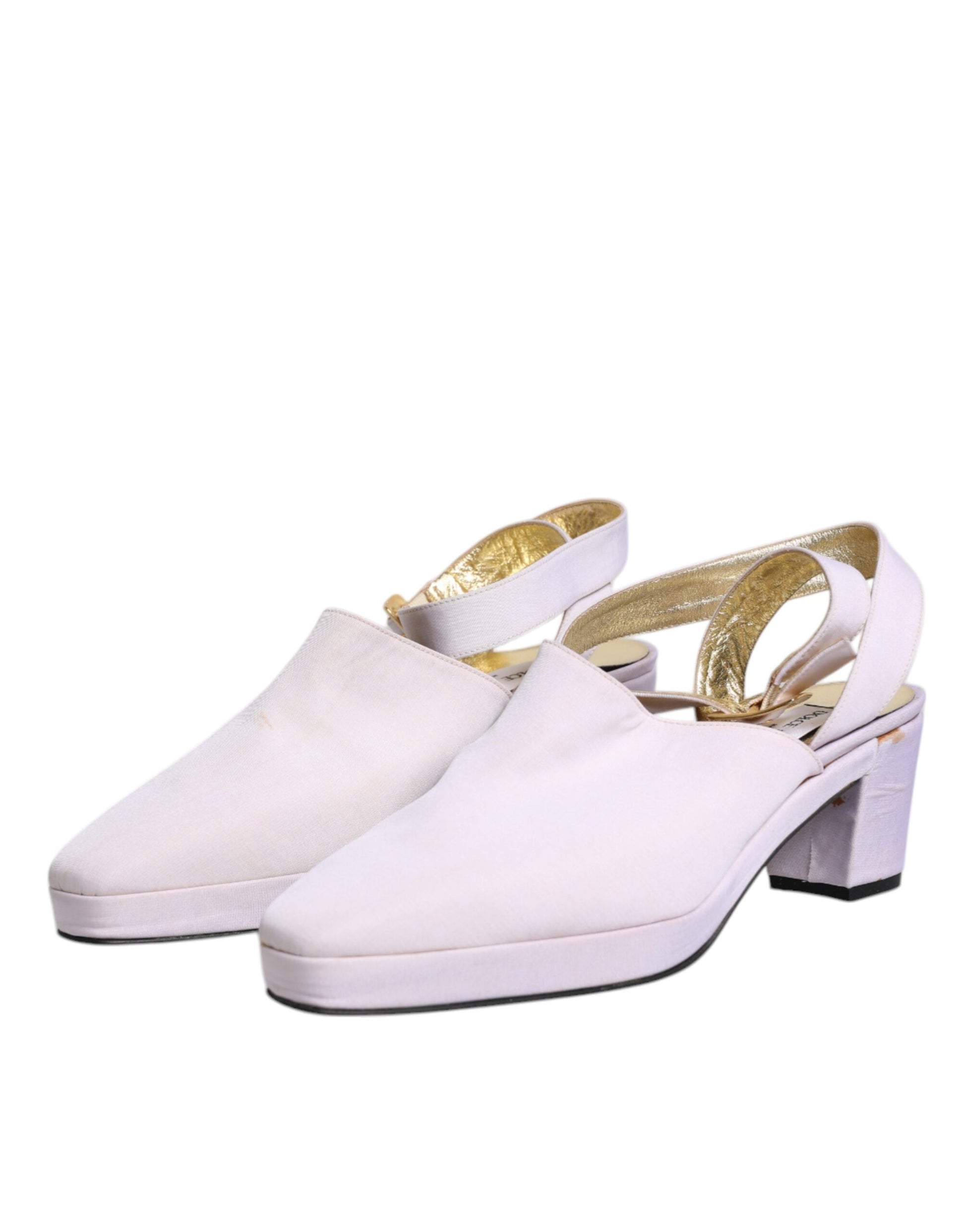 Pair of white high heel shoes with gold accents